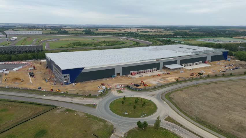 Aerial drone orbit panning view of large warehouse distribution centre construction site in Corby Northamptonshire England UK