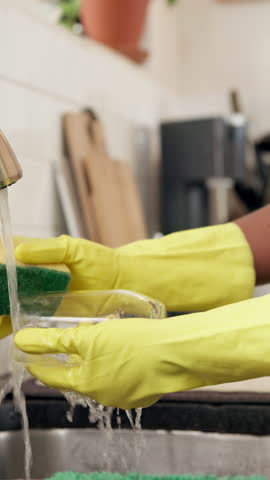Hands, dishes and cleaning in kitchen, home and gloves for dirt, bacteria and safety with sponge. Person, faucet and routine for washing glass for germs, PPE or cloth with hygiene at apartment
