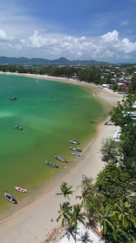 Aerial left pan shows Bang Tao Beach, longtail boats, Choeng Thale, Phuket
