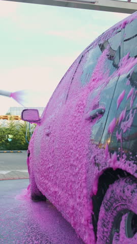 Enjoy the vibrant pink foam car wash that makes cleaning fun with bright bubbles and suds