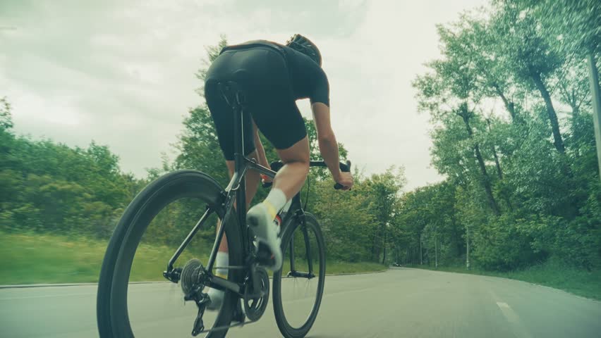 Outdoor Endurance Exercise Cycling. Healthy Lifestyle. Professional Cyclist Riding Road Bike. Athlete Cycling Training. Racing Bicycle Recreational Sport. Cyclist Intense Workout Performance Training