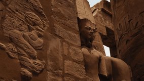 Large stone statue of an Egyptian pharaoh at Karnak Temple in Luxor, Egypt. Ancient ruins and historic sculpture from the temple site. - Powered by Shutterstock - Get 15% off with code: PIKWIZARD15