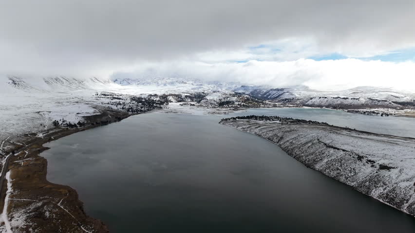 Snowy Caviahue lake and dramatic winter clouds over Andes mountains in Argentina