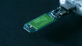 Flashing red LED and a lines of program code moves on a microchip in a circuit board of usb flash drives, symbolizing the operation of an electronic device or downloading data. Closeup. Macro - Powered by Shutterstock - Get 15% off with code: PIKWIZARD15