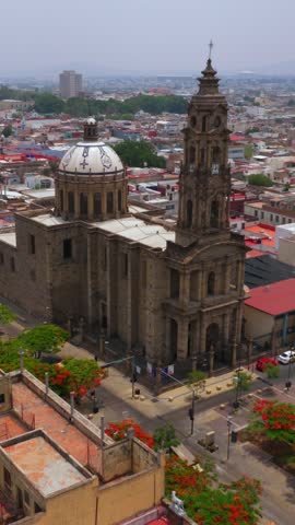 Wide vertical aerial of San José de Gracia Temple with dome and tower along Avenida Fray Antonio Alcalde in Guadalajara’s historic center