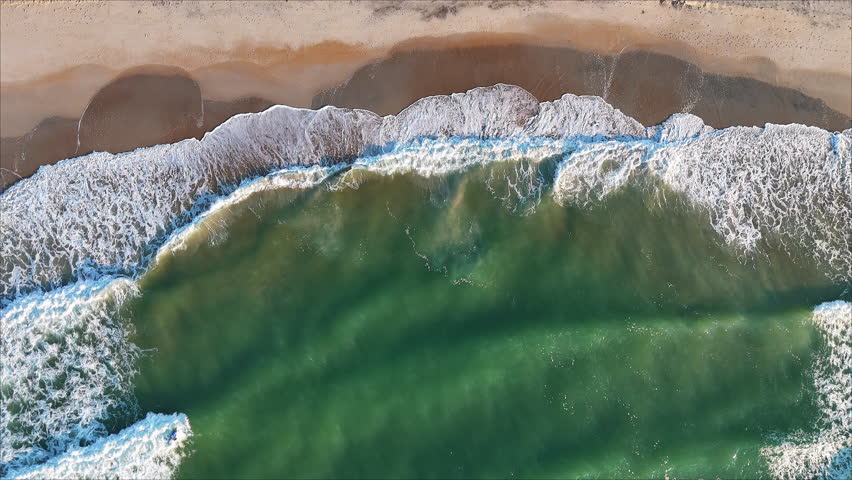 A Nadir view of ocean waves rolling onto a beach in Surf City NC