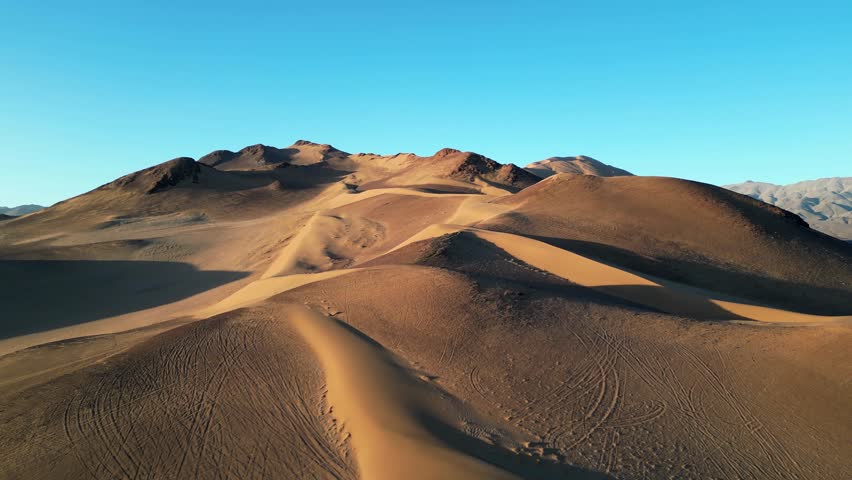 Drone footage of otherworldly sand formations at Medanoso dune in Chile’s desert during sunset.