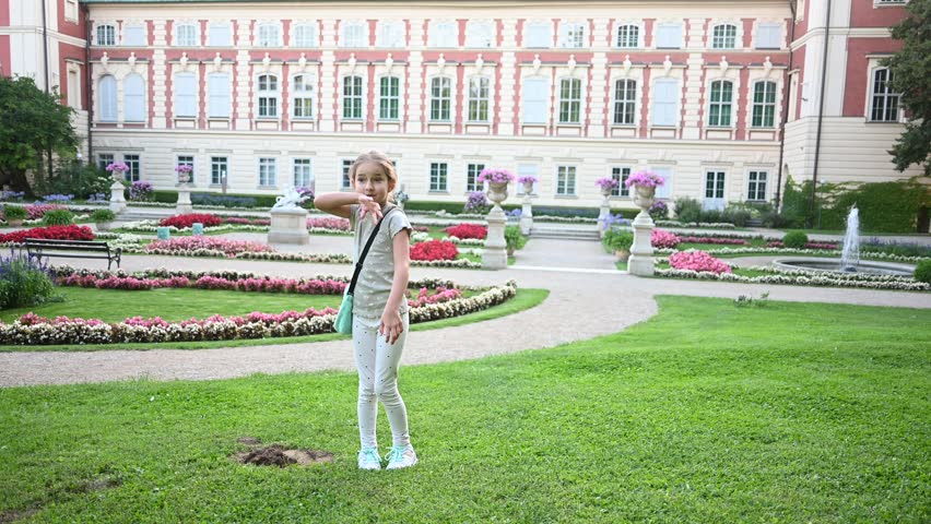Joyful Little Girl Twirling Happily in the Beautiful Palace Garden in Lancut, Poland