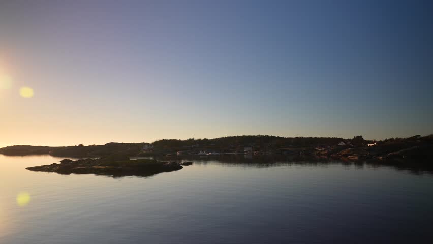 Artic Circle golden hour sunset sunrise sun flare on horizon reflection Norway Sweden coastline islands Hovedøya Sandefjord Strömstad Oslofjord ferry boat ride costal seaside town winter clear skies