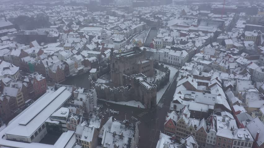 Aerial view of the snow-covered Gravensteen Castle surrounded by the city
