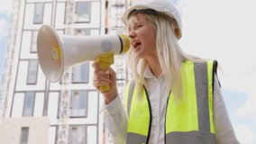 Construction site leader gives instructions using megaphone during project updates in urban setting with modern buildings - Powered by Shutterstock - Get 15% off with code: PIKWIZARD15