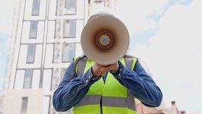 Construction worker holds megaphone on urban site while directing activities during bright daytime - Powered by Shutterstock - Get 15% off with code: PIKWIZARD15
