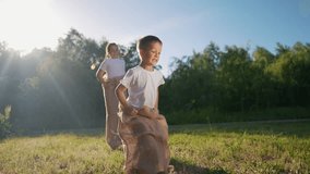 Two boys in field. Children race in sack outdoors. A young girl is playing with a teddy bear in the grass and is very competitive and energetic. A pair of boys in a lifestyle meadow. - Powered by Shutterstock - Get 15% off with code: PIKWIZARD15