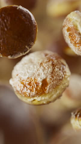 Looping animation of a group of donuts. Many donuts slowly rotate in the background in space. Vertical composition. Defocus. Close-up. Cycle.