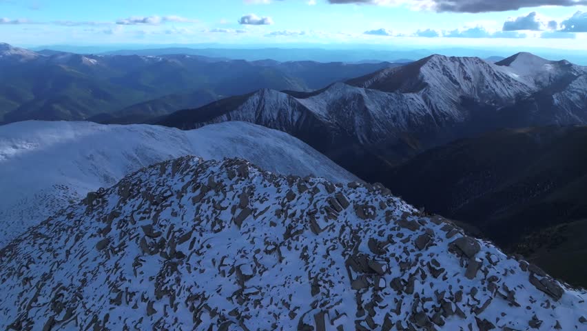 Mt Mount Shavano snow covered dusting summit of Tabeguache Huron Peak aerial drone Colorado shaded blue hour Rocky Mountains Mt Elbert Sawatch Range above treeline fall autumn forward pan up motion