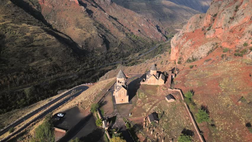 Aerial revealing view Noravank monastery complex, 13th-century Armenian monastery. Holy Mother of God church.Noravank at Amaghu. Red cliffs gorge by Arani village. Tourist destination in Armenia