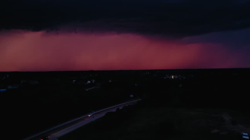 A lightning bolt strikes near a small town, highlighting the vulnerability of isolated communities in the face of extreme weather. Minnesota, USA
