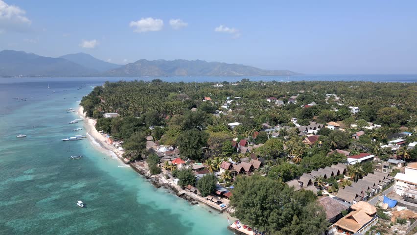 Aerial view of Gili Air island, Indonesia, with tropical coastline, turquoise water, and tropical resorts. Scenic travel destination near Lombok.