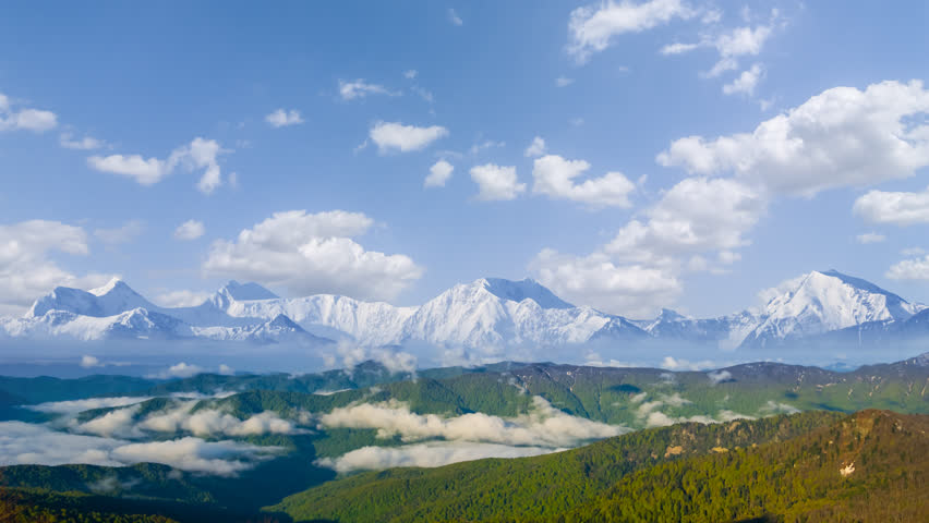 snowbound mountain valley in dense mist and clouds, natural travel time lapse scene