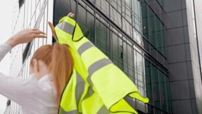 Smiling woman removes jacket near modern building on a sunny day in urban setting - Powered by Shutterstock - Get 15% off with code: PIKWIZARD15