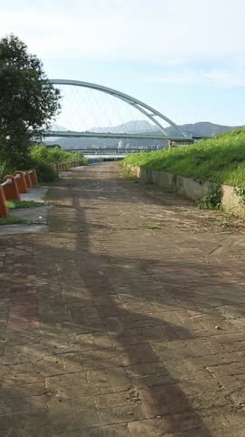 Road runner caucasian man running near the river in Taipe city. Jogging on a sunny day of summer with beautiful view in Taiwan. Exercising Concept. Sports lifestyle