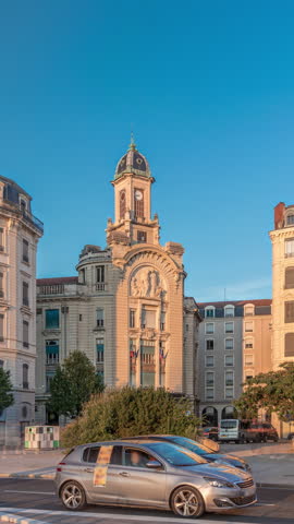 Hyperlapse of Place Antonin Jutard and the Mutuality Palace facade from the waterfront near Guillotiere Bridge in Lyon, France. Traffic flows on Quai Victor Augagneur under a blue sky timelapse