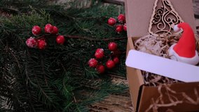 Christmas tree and red berries, blank sale tag, label. Gift box on wooden table, walnut wood. Christmas decorations and small Santa hat. Rustic style, cottage. Merry Christmas and Happy New Year - Powered by Shutterstock - Get 15% off with code: PIKWIZARD15