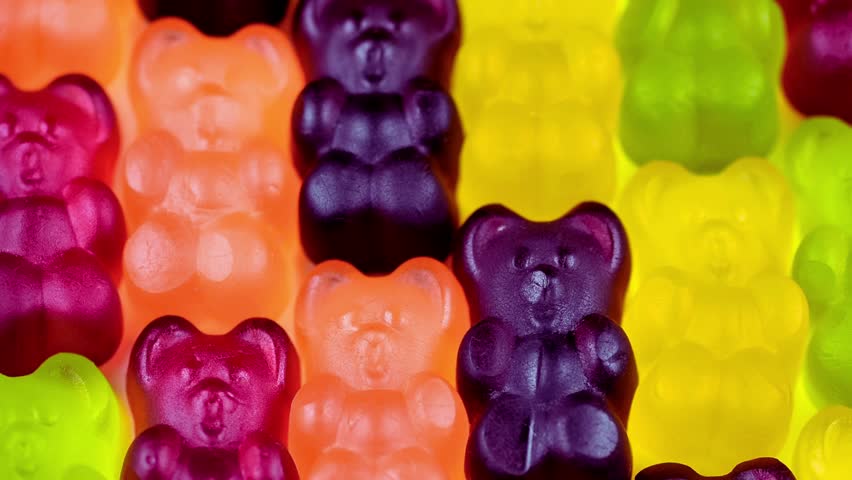 Close-up HD video of colorful gummy bears candy background. Bright, shiny jelly bears create a fun, sweet, and vibrant texture, perfect for food, sweets, confectionery, party, and abstract design.