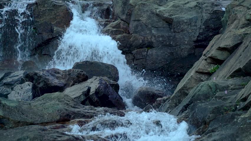 Cascade waterfall in slow motion among rocks in a gorge