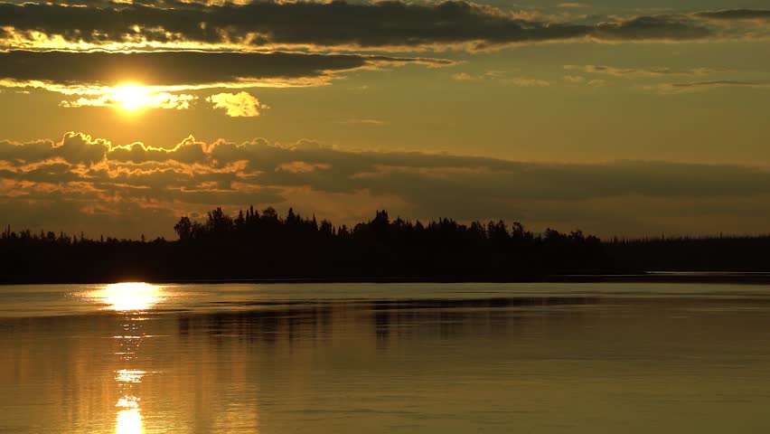 Autumn yellow sunset over clouds near forest with forest river