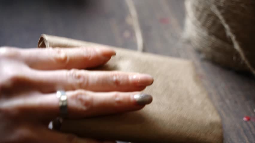 Close-Up Tying Leather Wallet Wrapped in Kraft Paper with Jute Twine