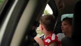Family road trip adventure, Mother and son enjoying the drive, Looking out the car window, Child experiencing travel excitement, Parent and child travel moment, Vacation memories on the road, Family - Powered by Shutterstock - Get 15% off with code: PIKWIZARD15