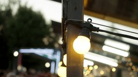 A detailed view of lanterns, emitting a warm, golden glow, suspended from a market stall at a street food festival. Close up - Powered by Shutterstock - Get 15% off with code: PIKWIZARD15