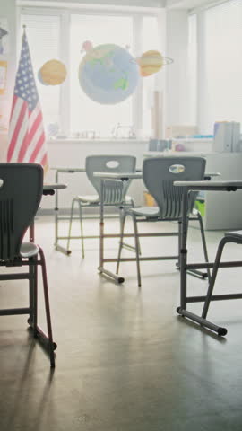 American Primary School: Interior of Empty Classroom with Desks for Students, Chalkboard, Hanging Models of Solar System and Colorful Posters. Creative Space for Children Studying. Vertical Shot.
