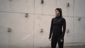 A strong female athlete poses in stylish activewear against an urban backdrop - Powered by Shutterstock - Get 15% off with code: PIKWIZARD15