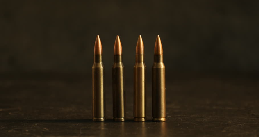 Firearm cartridges on black background with smoke, closeup