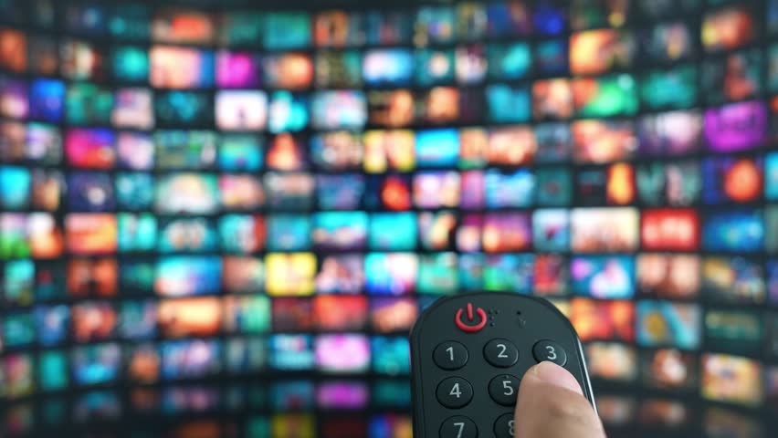 The act of selecting content by remote control on a big TV embodies smart technology, immersive leisure, digital connectivity, entertainment variety, and the comfort of enjoying movies at home.
