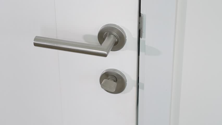 Turning the lock to open the door underscores daily habits that foster home safety, trust in traditional security methods, personal vigilance, prevention of unauthorized access, and self-reliance.
