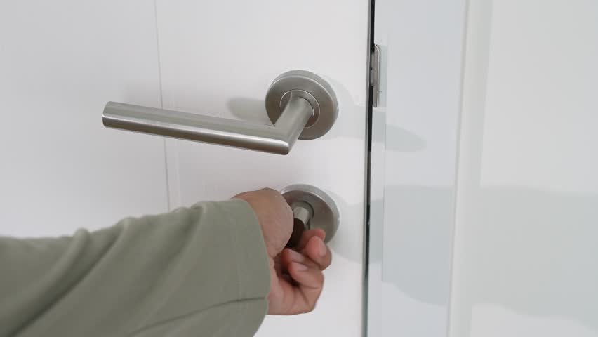 Turning the lock to open the door underscores daily habits that foster home safety, trust in traditional security methods, personal vigilance, prevention of unauthorized access, and self-reliance.
