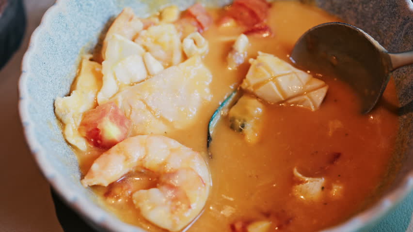 Close up of a creamy seafood stew with mussels, squid, and shrimp