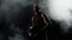 Close up of male boxer in dark smoke-filled gym in ring. Silhouette on dark background. Sportsman throwing boxing gloves to camera. 4K slow motion - Powered by Shutterstock - Get 15% off with code: PIKWIZARD15