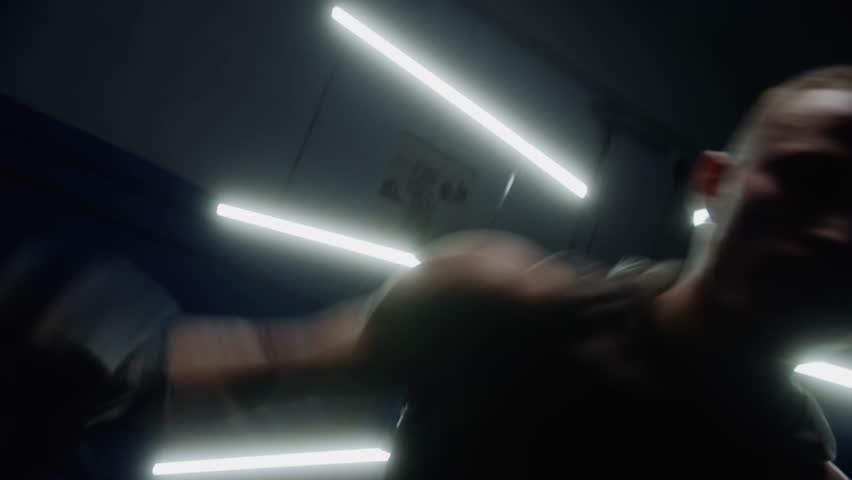 Silhouette of man jumping around and punching, getting ready to fight with light behind him, Front camera shot. Caucasian male
