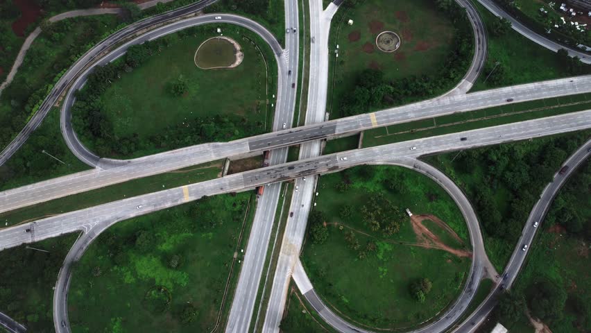 Aerial drone view of the clover-leaf junction on NICE Road, Bangalore, India, showing modern urban infrastructure and smooth traffic movement.