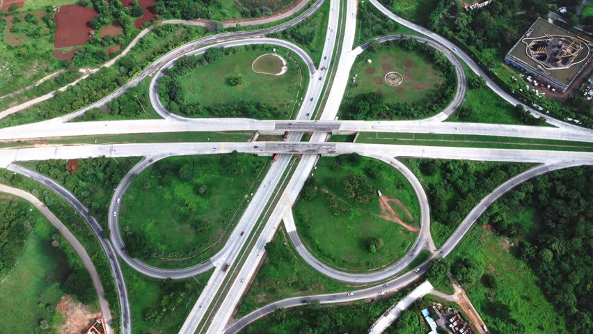 Aerial drone view of the clover-leaf junction on NICE Road, Bangalore, India, showing modern urban infrastructure and smooth traffic movement.