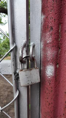 old padlock. mans hand open old metal padlock key. Wooden door in old house. A Man Closing His Store with Padlock and Metal Shutter. Close-Up. 4K Resolution.