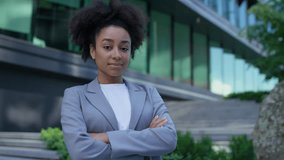Portrait of a confident young professional woman in a gray blazer with arms crossed, standing outdoors near a modern office building. - Powered by Shutterstock - Get 15% off with code: PIKWIZARD15