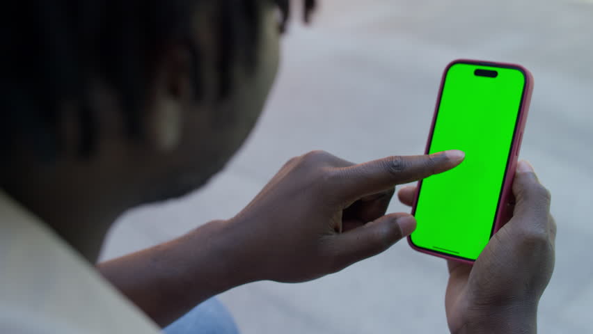 Detailed view of a man hand making a single tap on a smartphone with a green screen, suitable for mockups or apps.