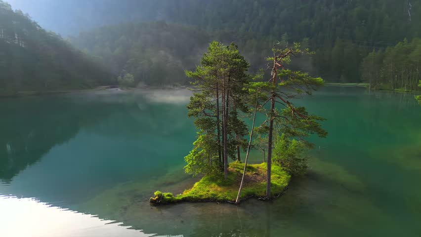 Small islands with pine-trees in the middle of Eibsee lake with Zugspitze mountain. Beautiful landscape scenery with paradise beach and clear blue water in German Alps, Bavaria, Germany, Europe.