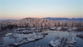 Shot flying over the Aegean sea with yachts and boats, approaching the mountain with buildings, filmed after sunset in Piraeus, Greece. Full moon in a clear sky with three birds flying towards it - Powered by Shutterstock - Get 15% off with code: PIKWIZARD15
