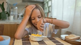 Young child eating fresh fruits with a fork at breakfast table in cozy kitchen. Peaceful morning atmosphere with natural light and healthy food - Powered by Shutterstock - Get 15% off with code: PIKWIZARD15
